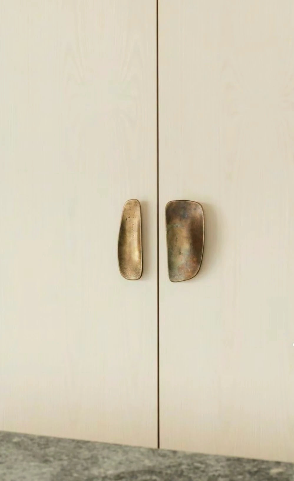 Sculptural ATHAR pulls on cream cabinet doors